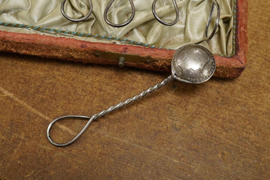 A cased set of twelve assorted white metal coffee spoons, with spiral stems and coin bowls.